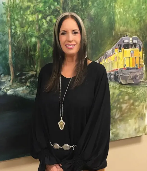 A woman standing in front of a painting.