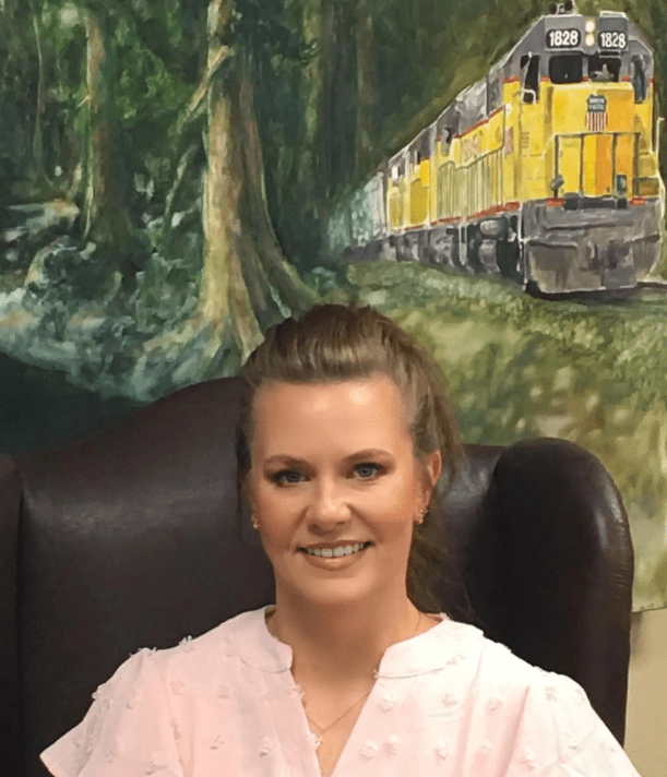 A woman sitting in front of a painting.